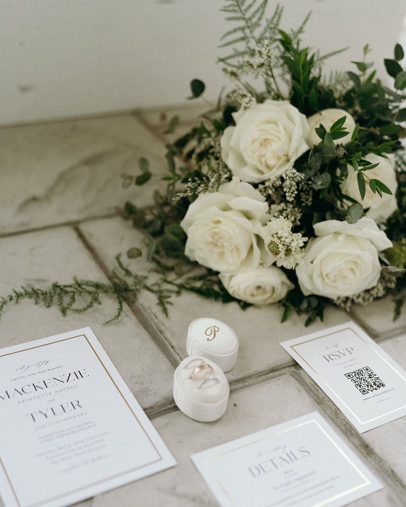 Editorial flat lay of wedding invitation and RSVP, wedding rings, and bouquet of flowers | Megan Smith Photo