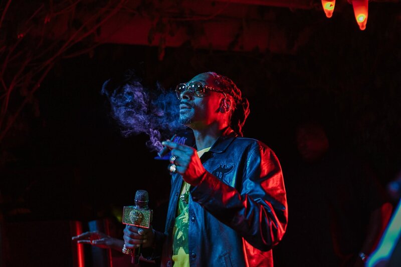  Snoop Dogg  performing at private reno event under colored lights and smoking