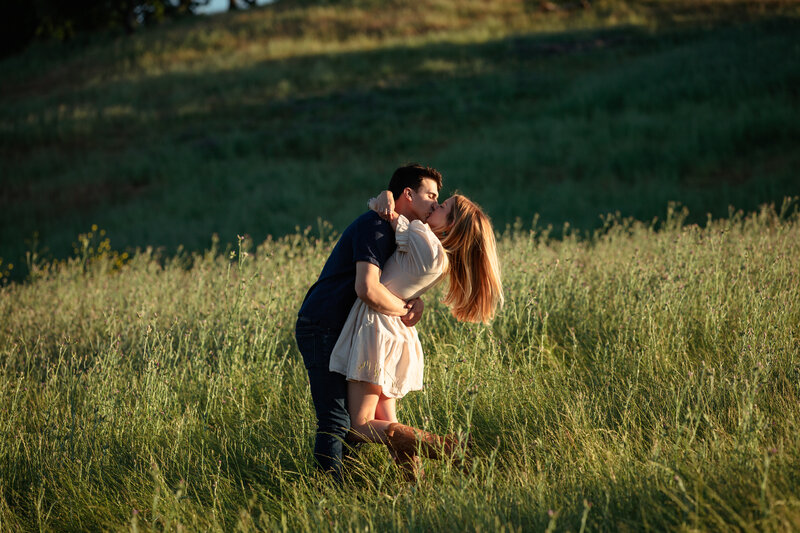 couple shares a kiss in the hills at sunset in California