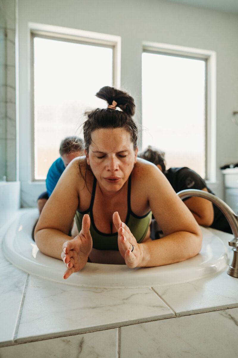 Mother laboring with strength and focus near a birth pool — empowering home birth photography in Weatherford by Poppy + Blue Photography