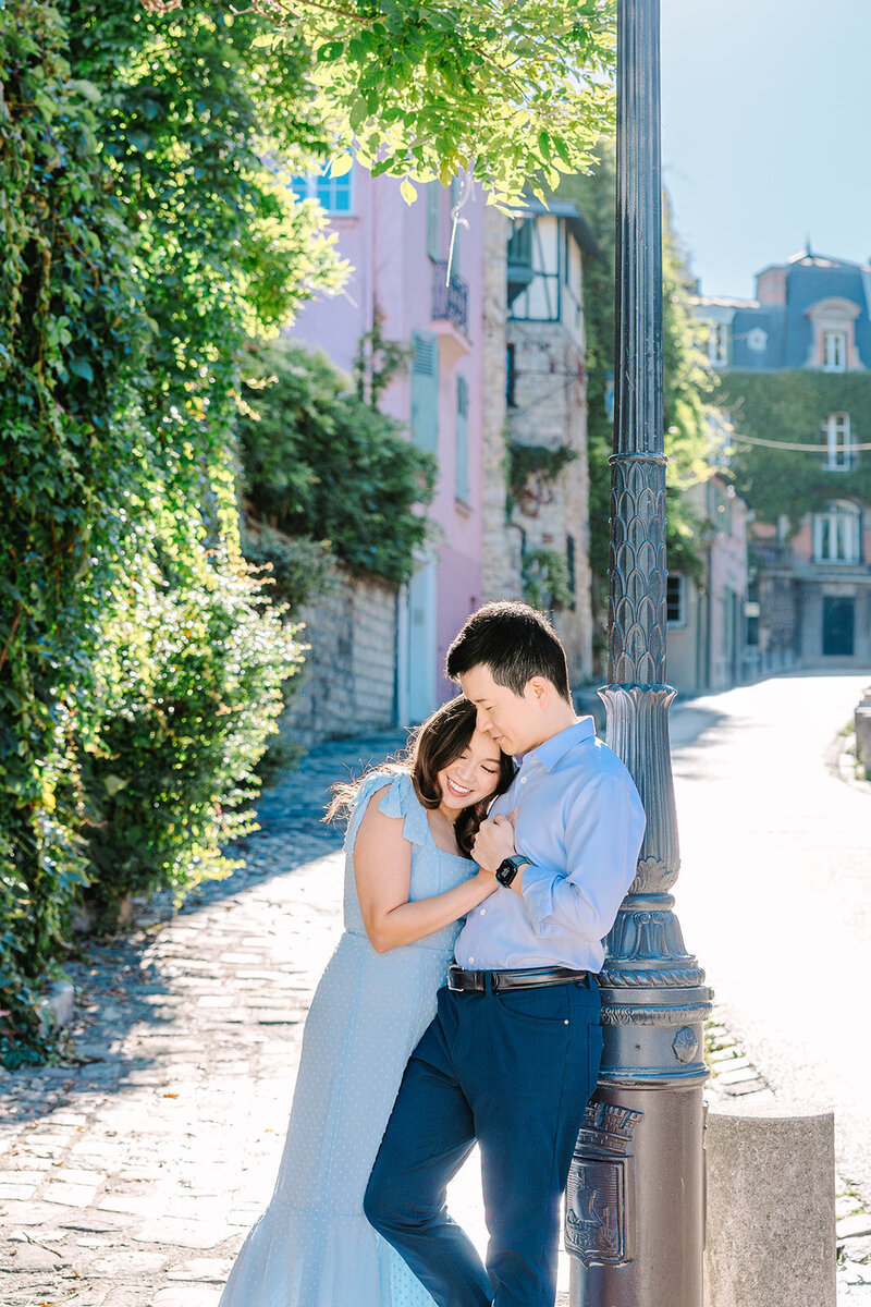 Smiling couple embracing during a romantic Paris photoshoot near the Eiffel Tower and Montmartre.