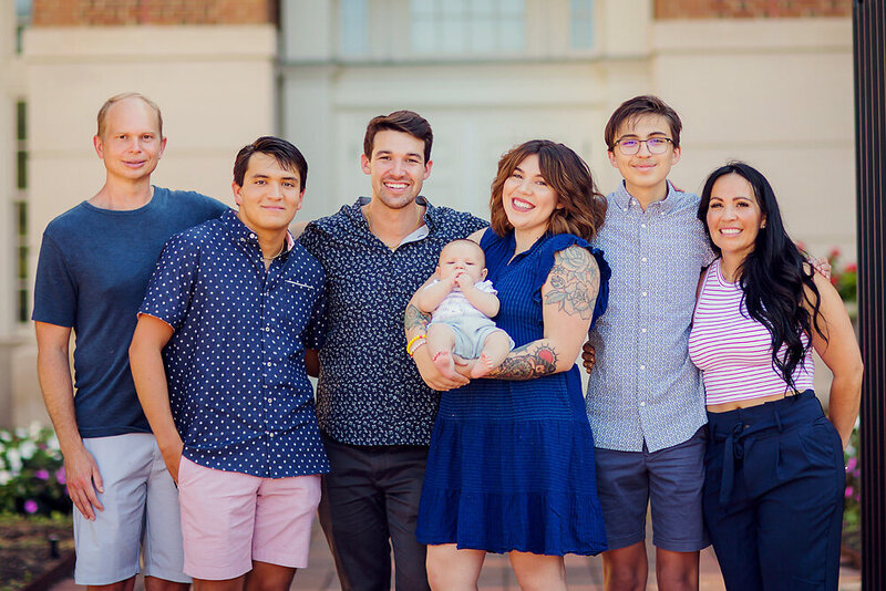 Family of six welcoming their newest family member, all wearing blue.