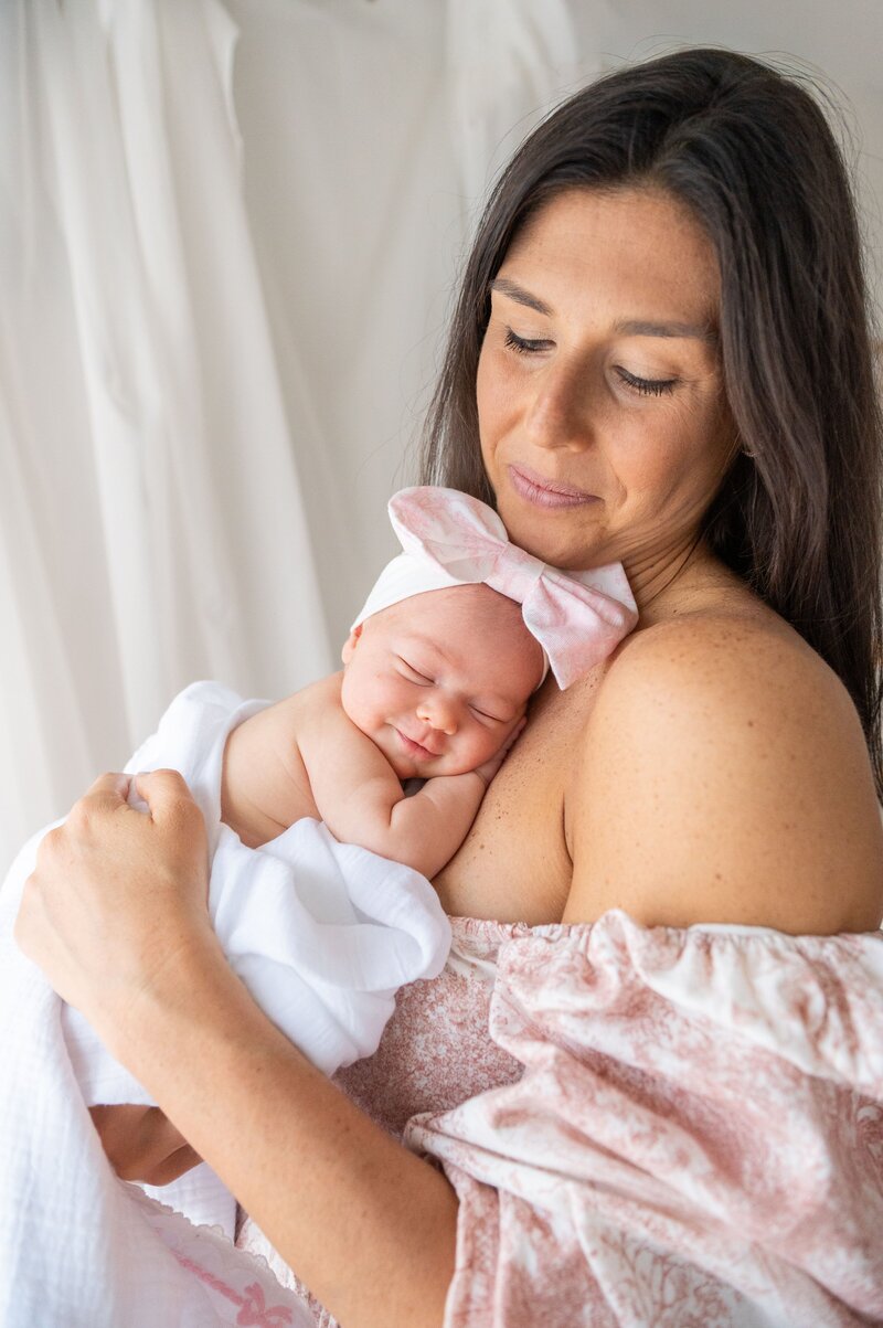 MOM HOLDING A NEWBORN TO HER CHEST IN HER BEL AIR MARYLAND HOME