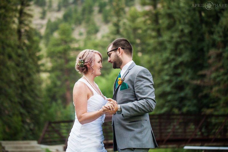 Bride and groom dance their first dance next to Fall River at their Outdoor wedding at Estes Park Condos