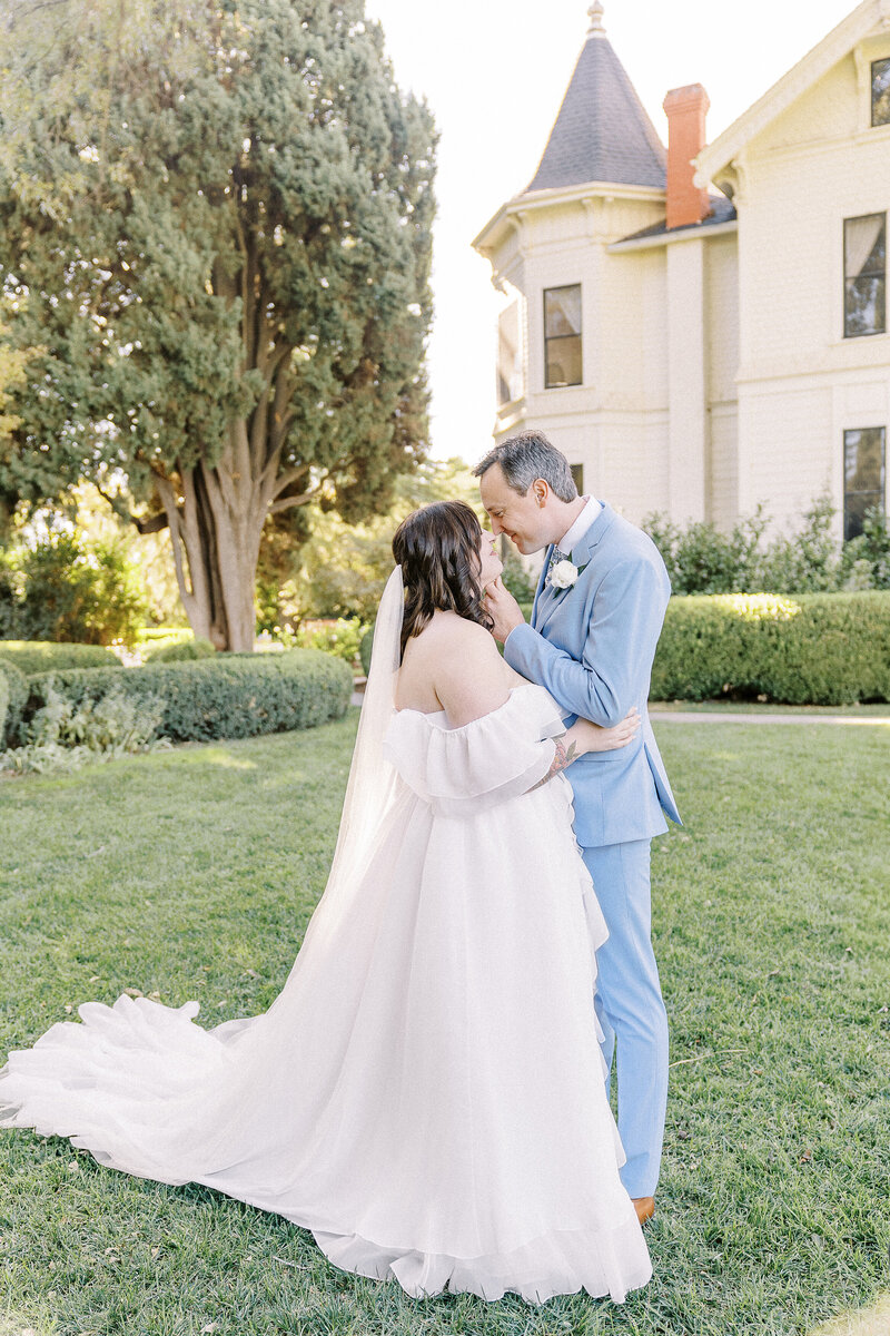 A groom lifts his brides chin as they share a giggle at their park winters wedding in Sacramento, CA
