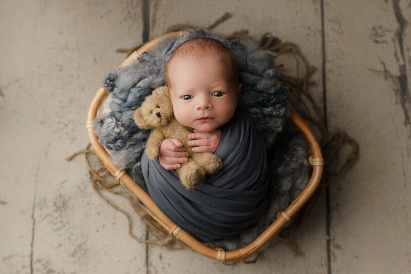 newborn baby boy in blue in a basket