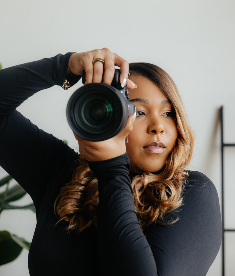 A photographer posing while holding her camera.
