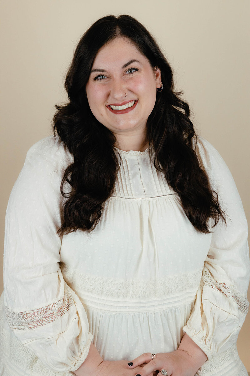 Taressa, a wedding and event planner in Oregon, smiles at the camera in a studio. 