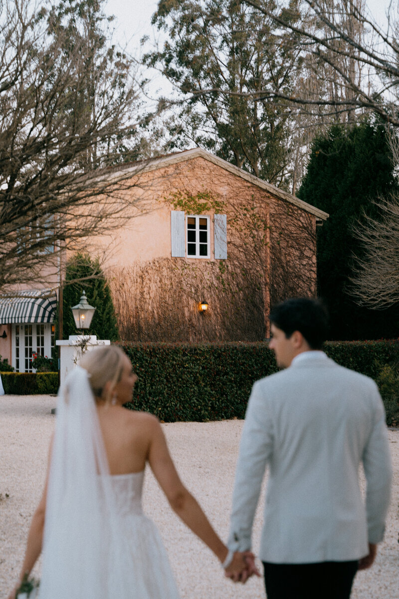 Bride and groom holding hands and walking at their Redleaf elopement, Hunter Valley