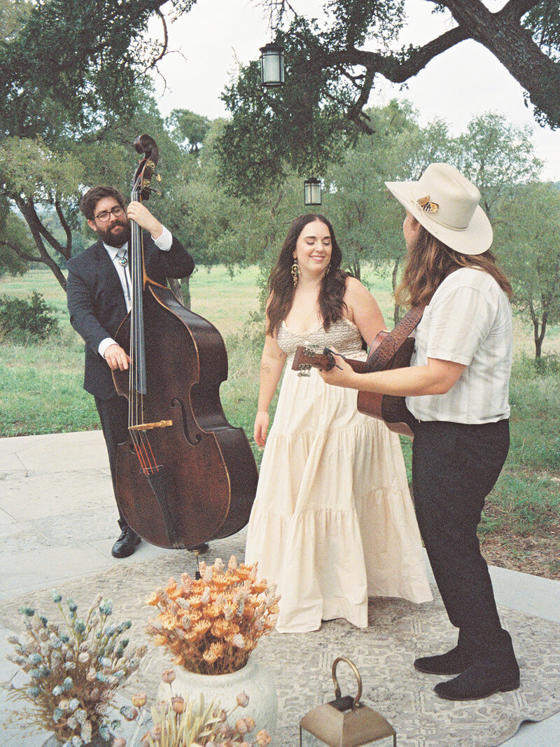 Mikaela Kahn live wedding vocalist and her husband performing music while a man plays a cello with them