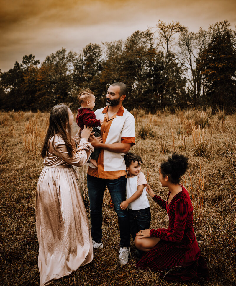 dad playing with kids outside during a sunset family session