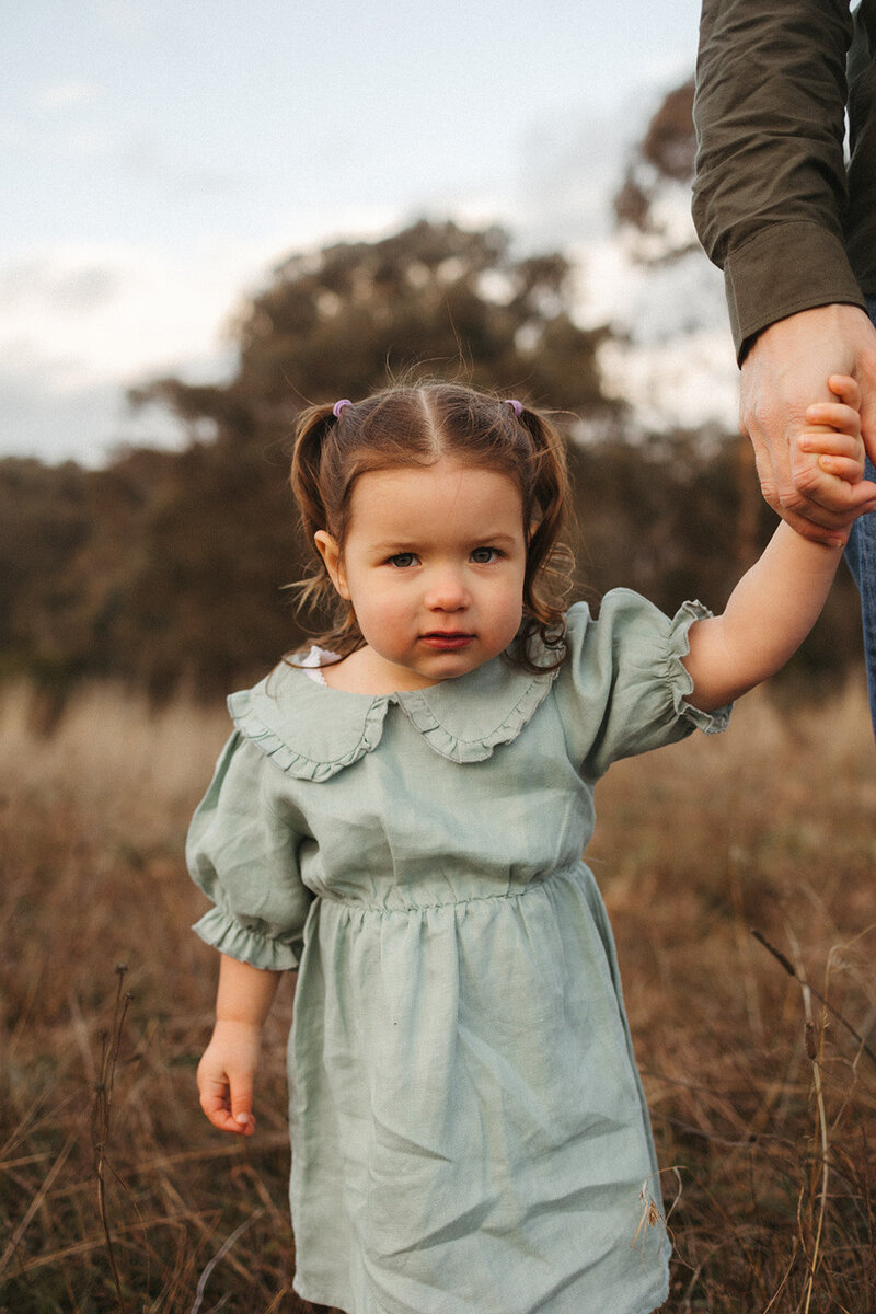 Family standing on dirt path with bushland backtround