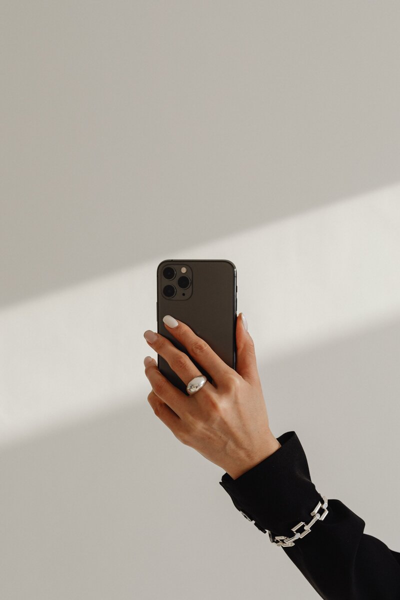 kaboompics_dark-classy-aesthetic-fashion-beautiful-asian-female-entrepreneur-in-black-suit-technology-and-devices-iphone-laptop-airpods-30062-min