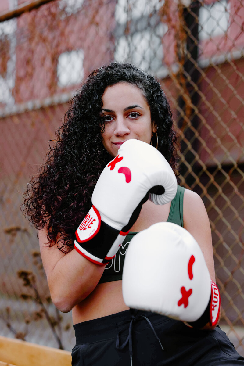 Rumble boxing instructor, Teresa Williams, wears Rumble boxing gloves