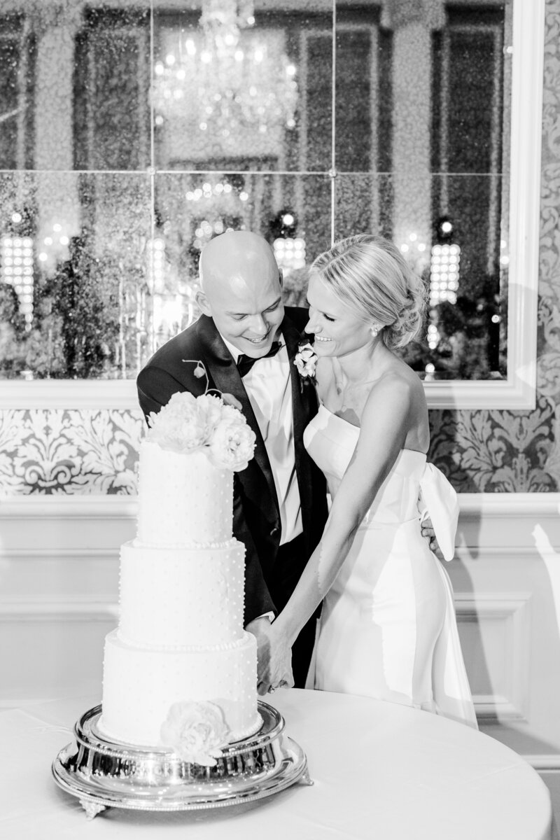 bride and groom cutting their cake during their wedding reception at the poinsett club