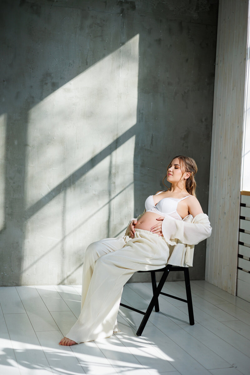 stylish-young-pregnant-woman-white-suit-is-sitting-chair-gray-background-pregnant-woman-white-underwear