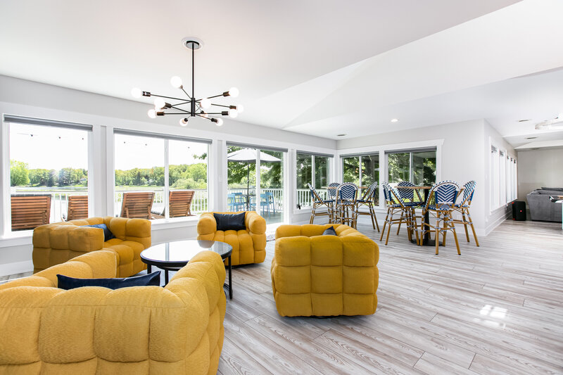 The perfect space to entertain.A Stunning living room with bold yellow chairs and tons of high top seating.