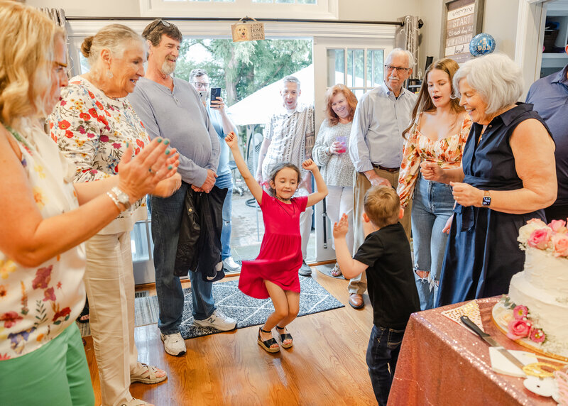 Kids dancing at a casual party while guests applaud