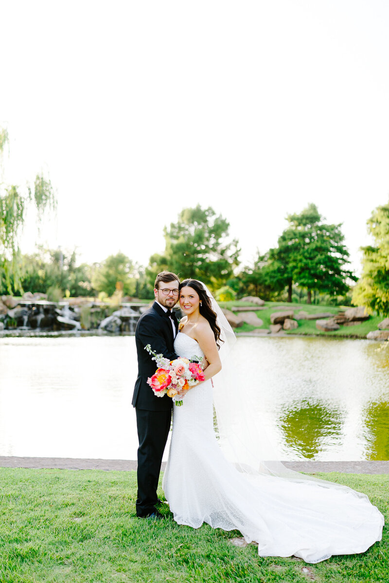 Experience Sydney and Braeden’s vibrant summer wedding at Cole’s Garden in Oklahoma City, featuring bold floral colors, elegant black suits, and a romantic garden party atmosphere.