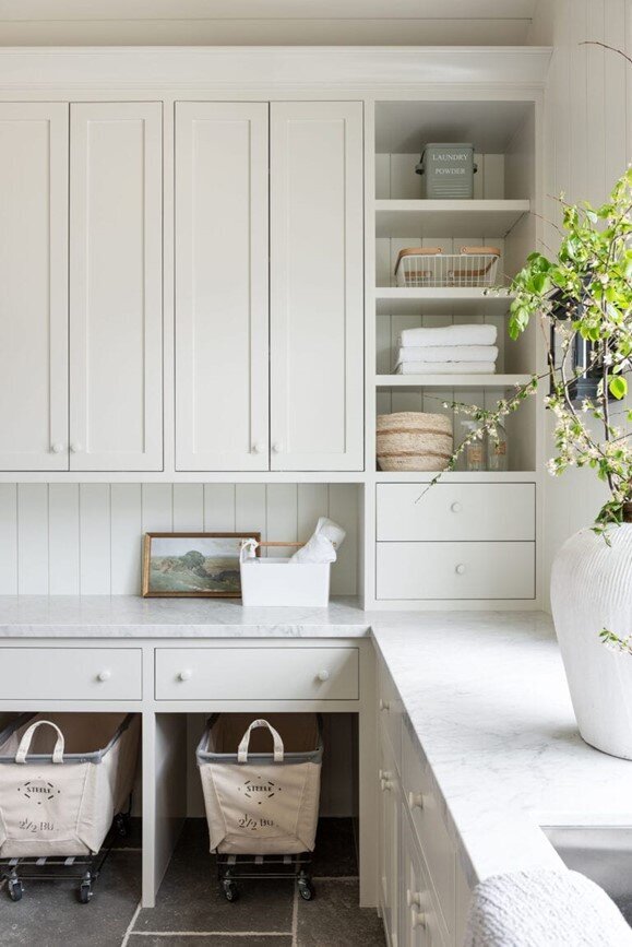 A bright white laundry room featuring a spacious white sink and a large white potted plant for a fresh, clean aesthetic.