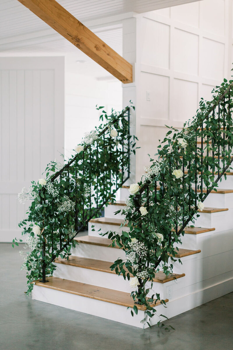 Staircase with greenery along the black railing