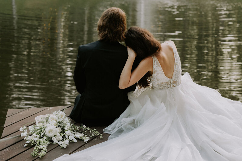 A seated bride and groom looking at the water at a Nashville outdoor wedding