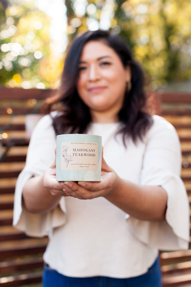 female-candle-maker-holding-candle-for-mini-brand-session-noda-charlotte