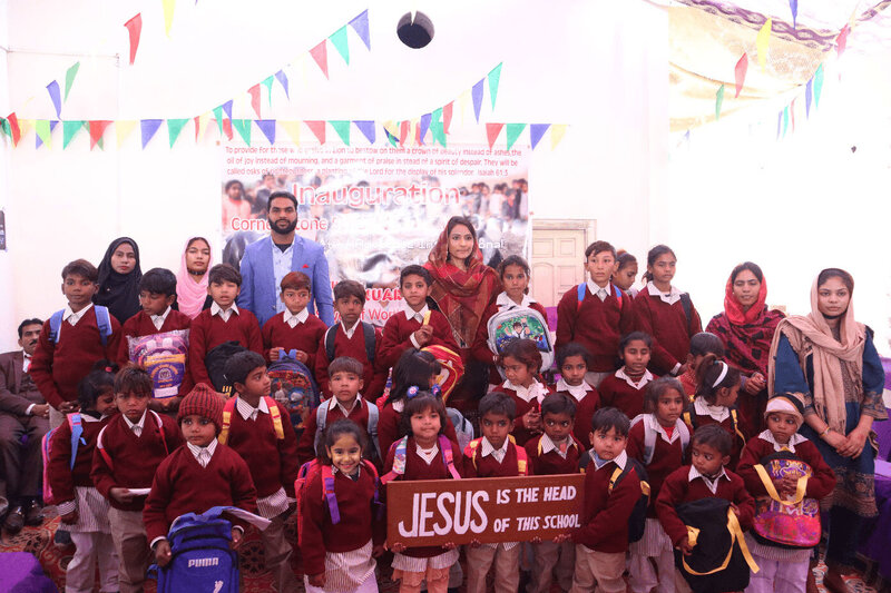 Members of the Advocate International team gather with the children who attend the school on the inaugural day.