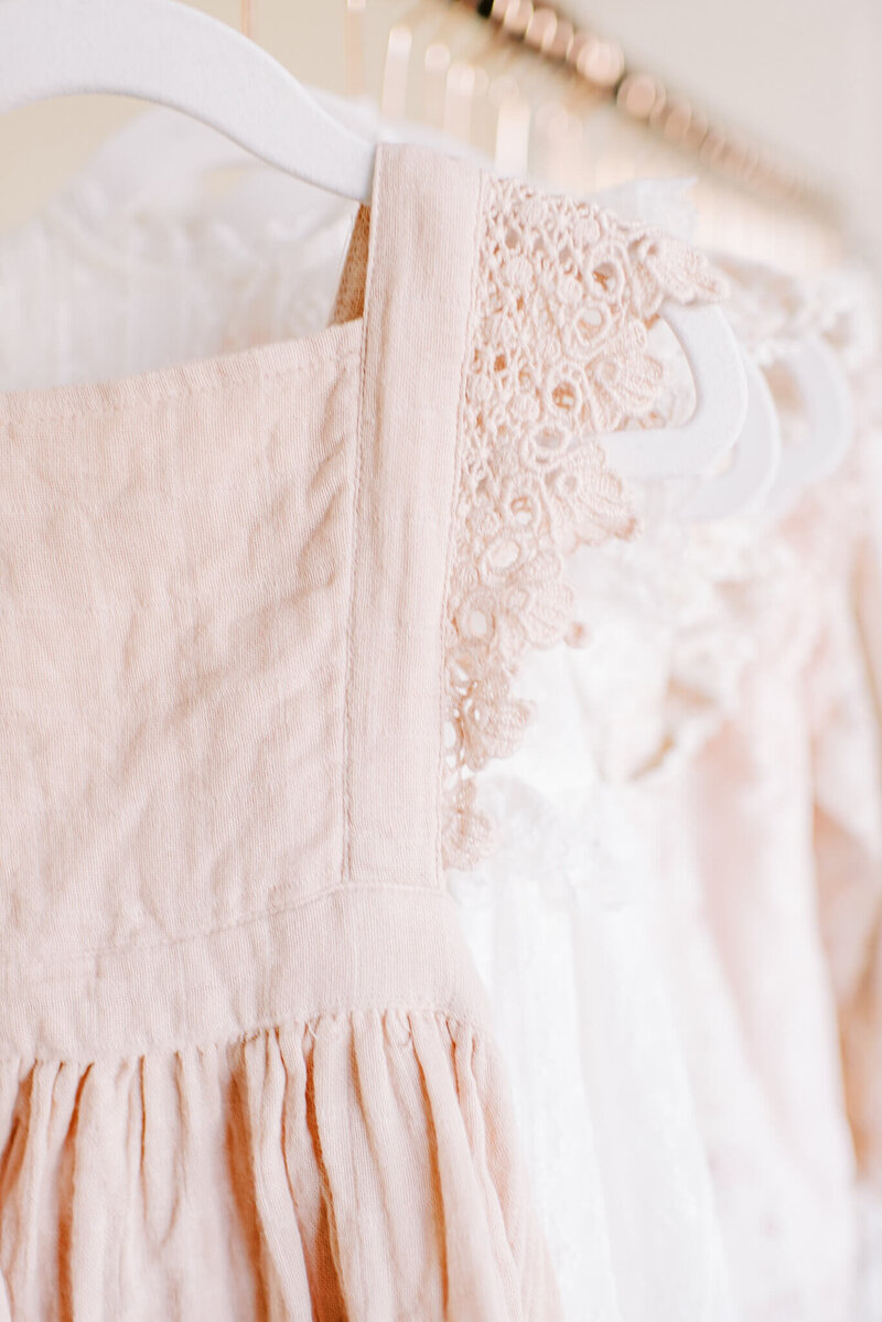 A pink muslin dress from Jamie Kay is shown on the clothing rack ahead of a client's family session