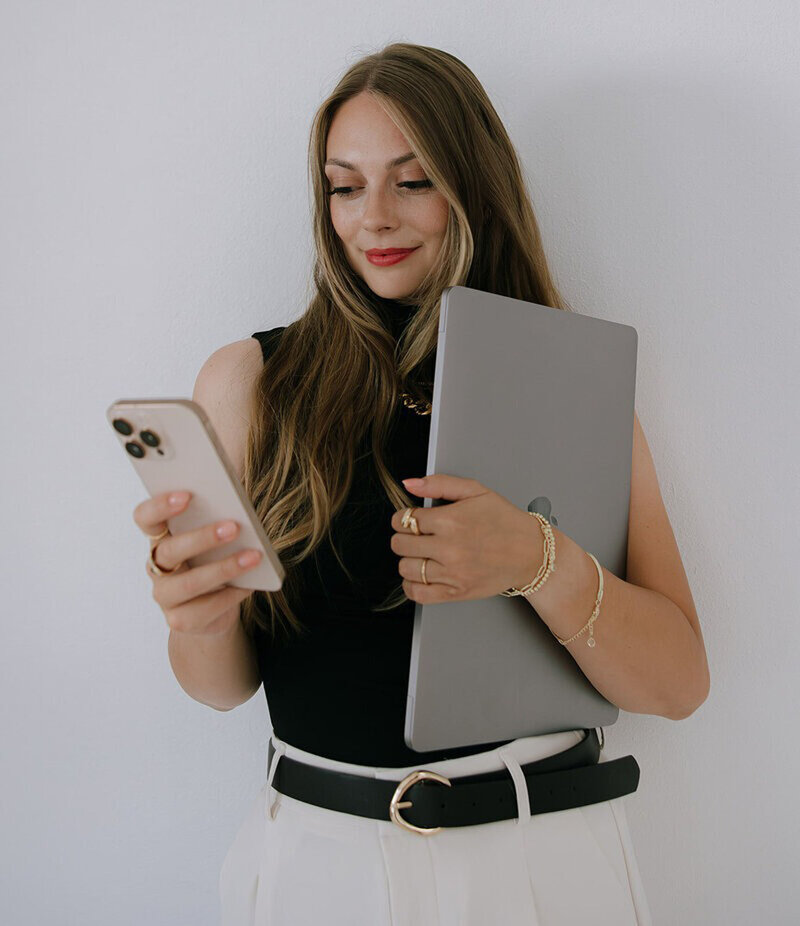 Founder of Palme design co looking at phone showing website design and branding packages