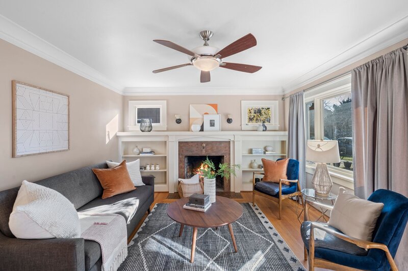 A living room featuring a fireplace, built in bookshelf, couch, chair and coffee table.