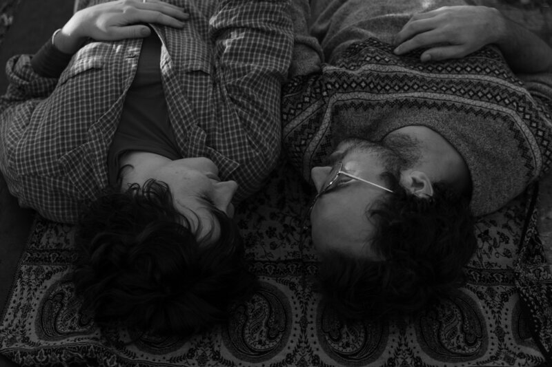 Black and white laying down couples photo of the couple smiling taken by a Minnesota couples photographer 