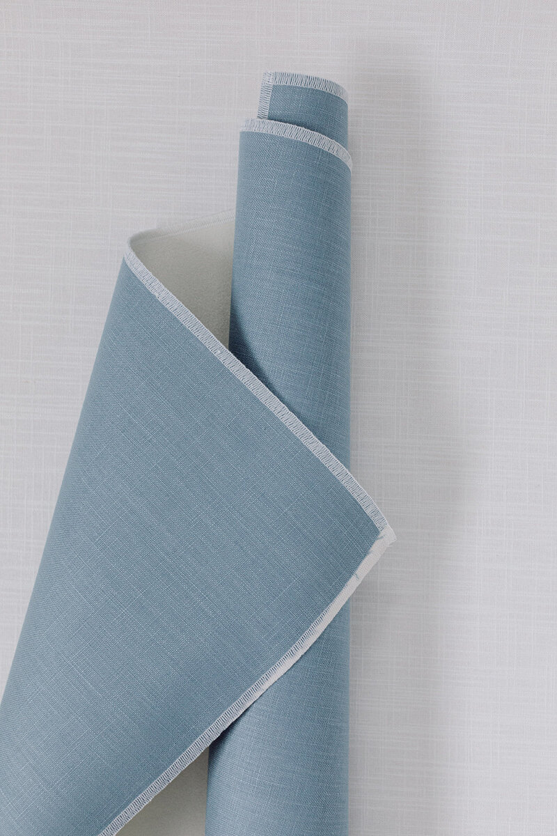 Soft blue linen flat lay mat styled with romantic paper goods and silk ribbon