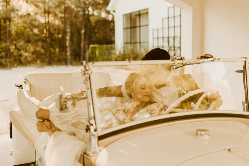 bride and groom in vintage car