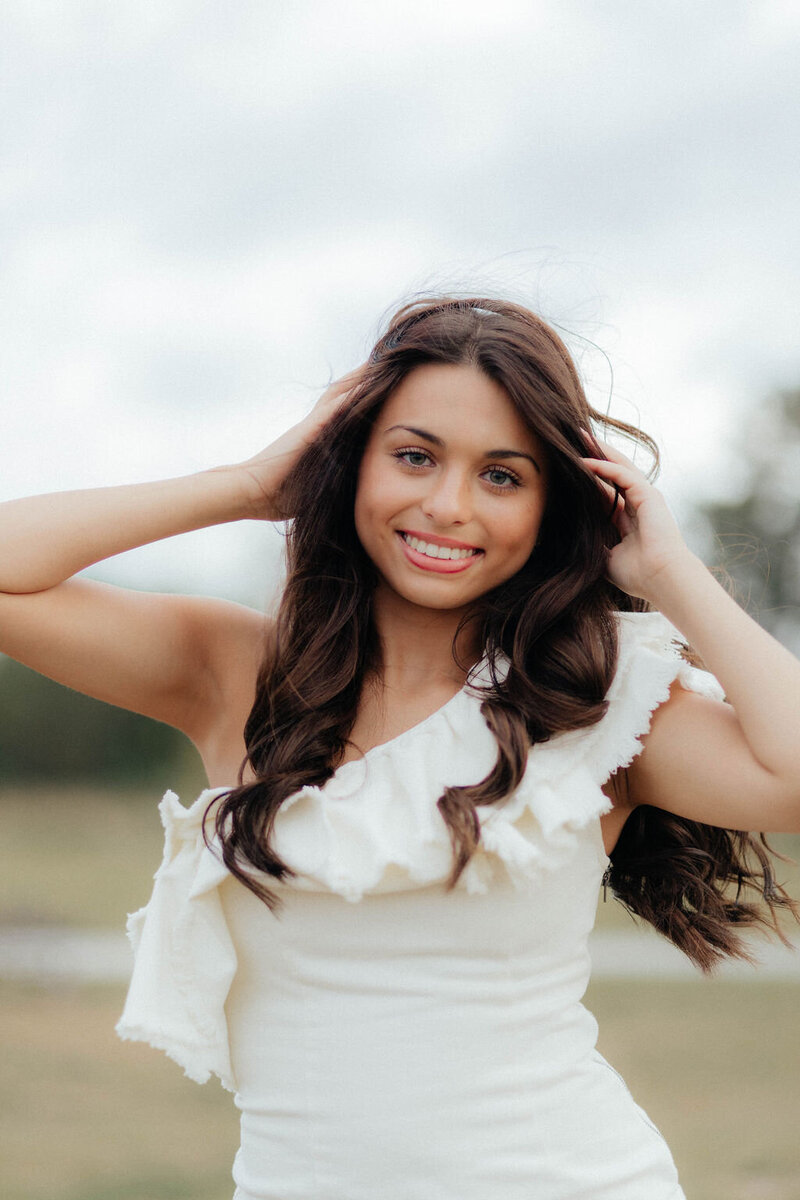girl posing with hands on head