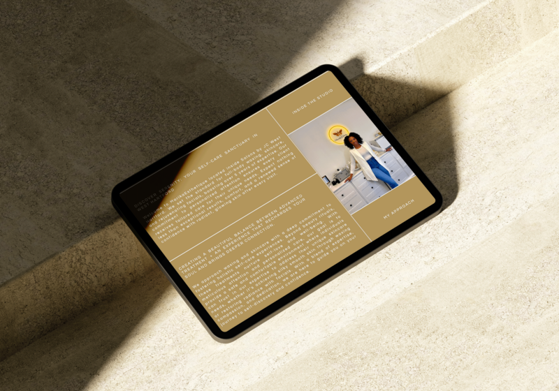Black tablet on beige stone surface displaying the website of Marikaesthetique, a beauty professional specializing in Aesthetics.