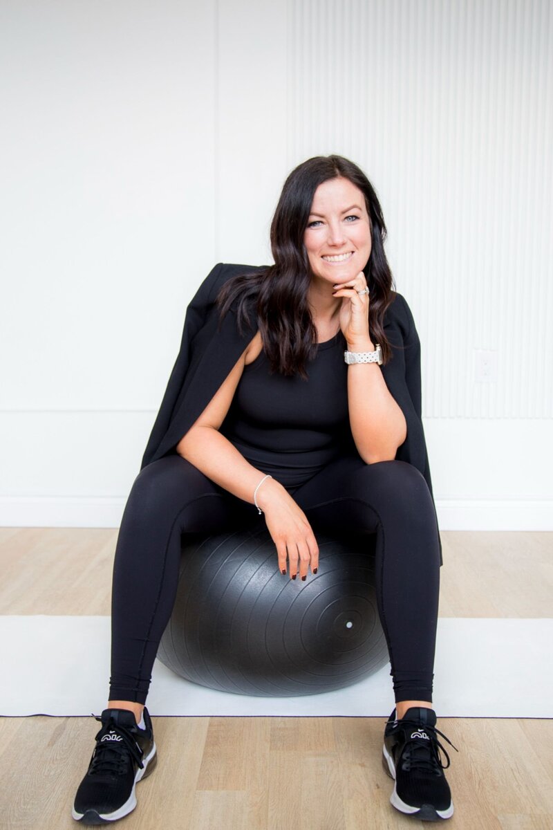 Erin smiling sitting on a yoga ball