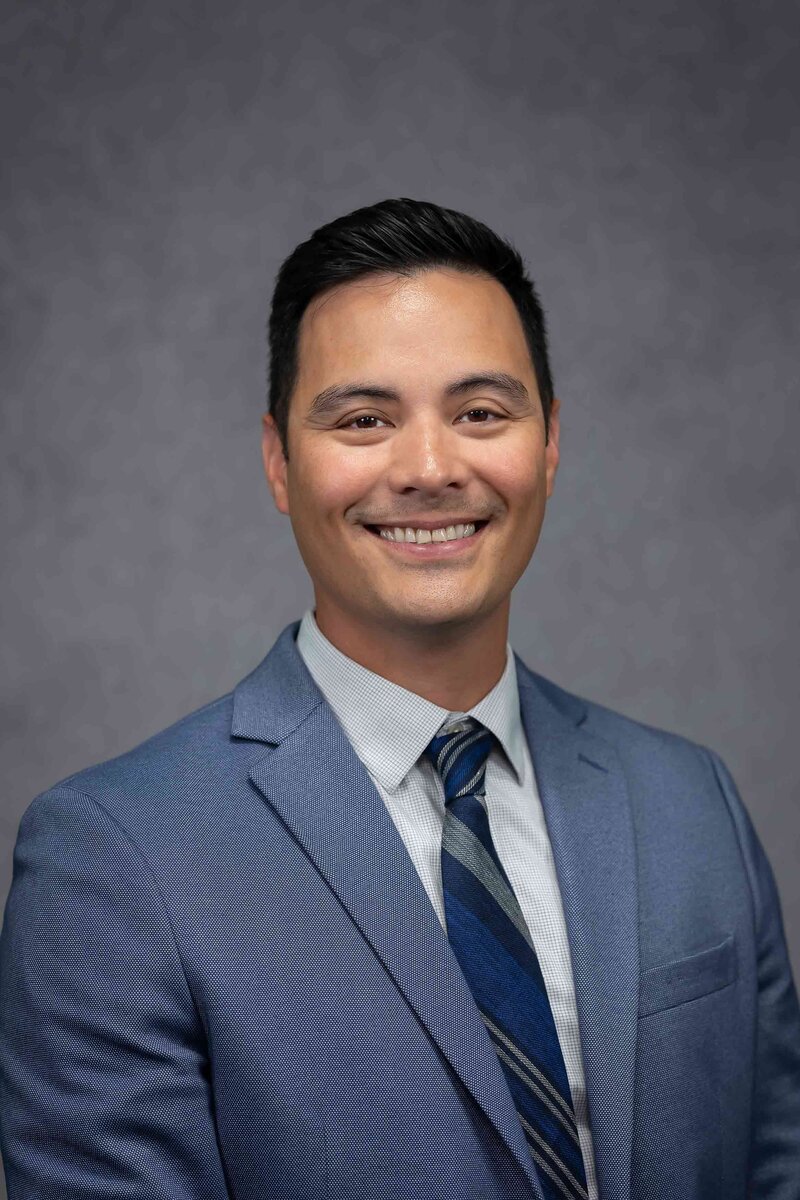 Personal branding headshot for a professional CV featuring a man against a grey background, from the Headshot Gallery Portfolio by Sophie K. Hunter in Dallas