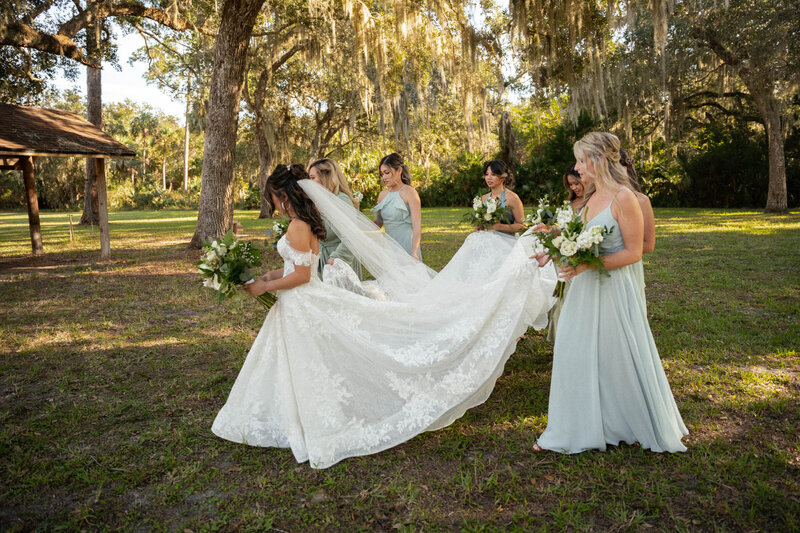 Bridemaids helping bride with her dress before her ceremony