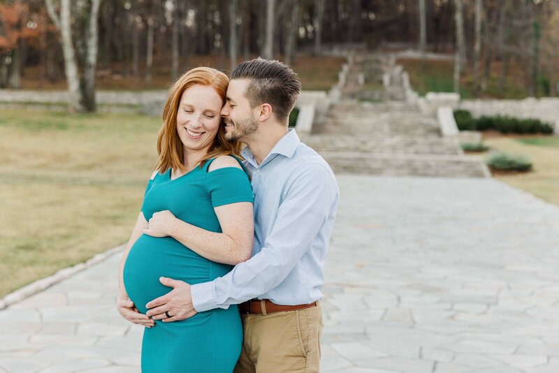 Maternity Photoshoot in Nashville Tennessee.  Husband nuzzling nose into wife's temple while hugging her baby bump.