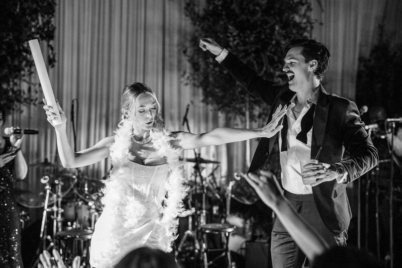 Bride in a mini dress on stage with her wedding band for a Dallas wedding