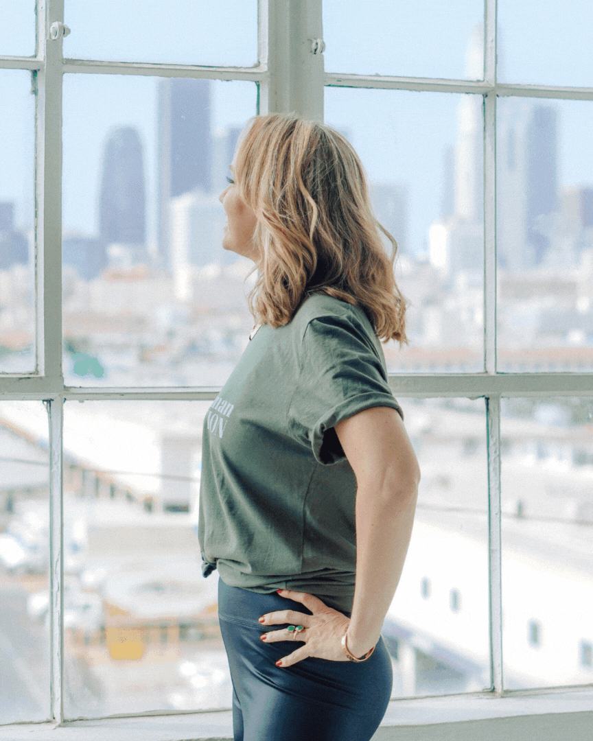 woman smiling and looking out at cityscape gif