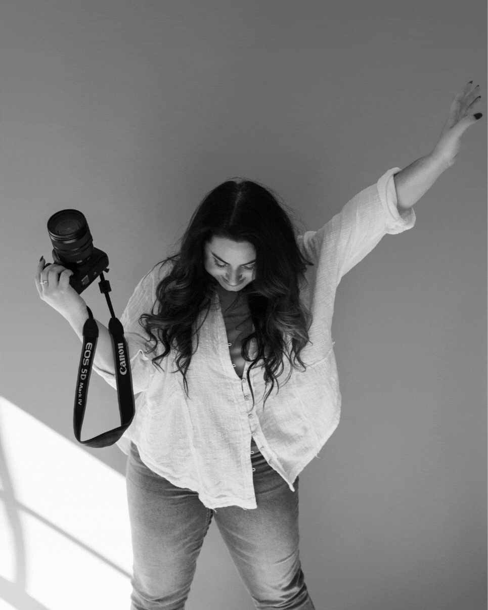 woman photographer holding camera and dancing