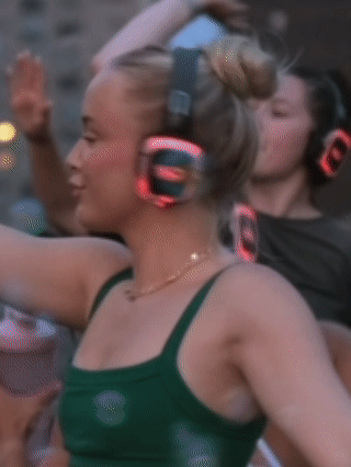 women with blonde hair in a bun dancing during a silent disco rooftop session