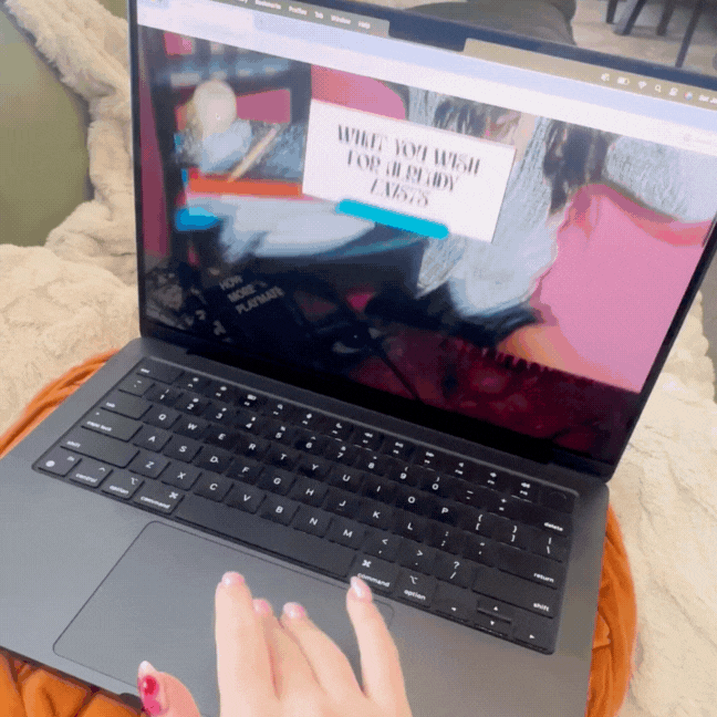 A woman scrolling through a nail artist's website on her laptop