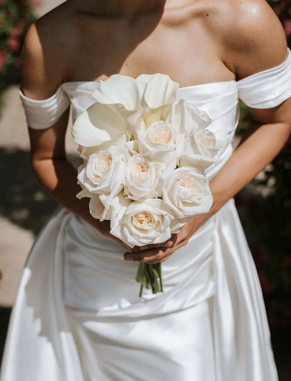 Braut im schulterfreien Satinkleid mit weißem Strauß aus Rosen und Callas; Licht betont natürliche hochzeitsfotografie und klassische hochzeitsfotos