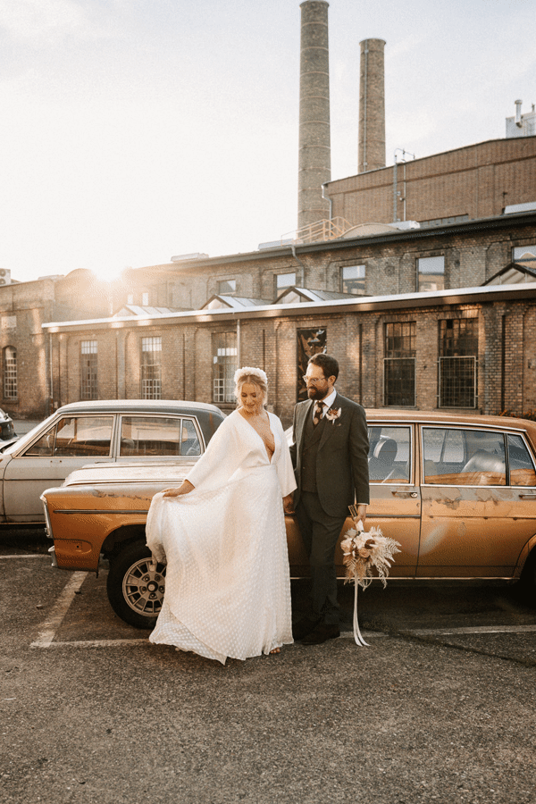 Brautpaar im Sonnenlicht stehend vor Oldtimer in Mainz
