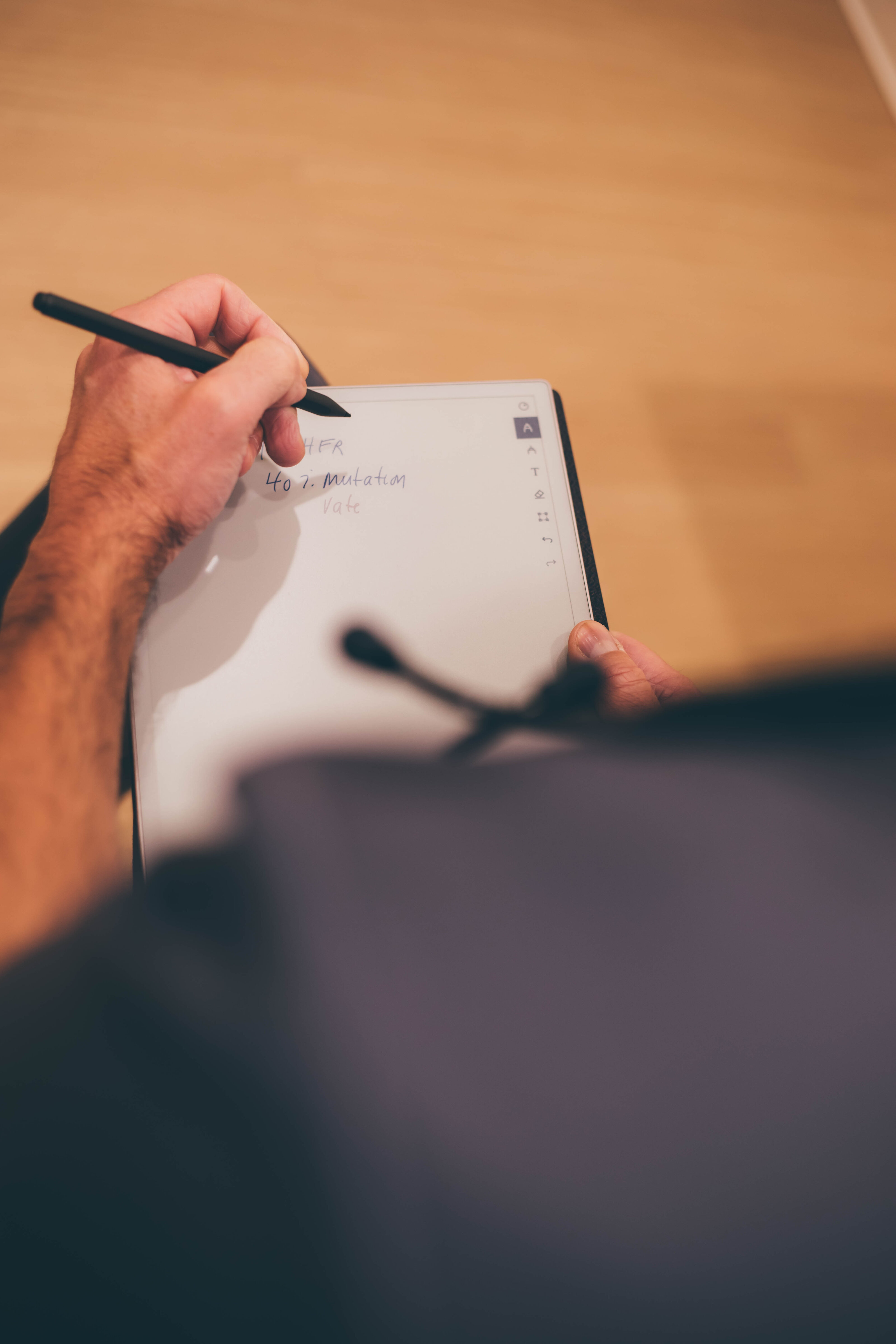 Close-up of a doctor writing patient notes on a digital tablet, reflecting the personalized care approach at Ivalo MD in McKinney, TX.