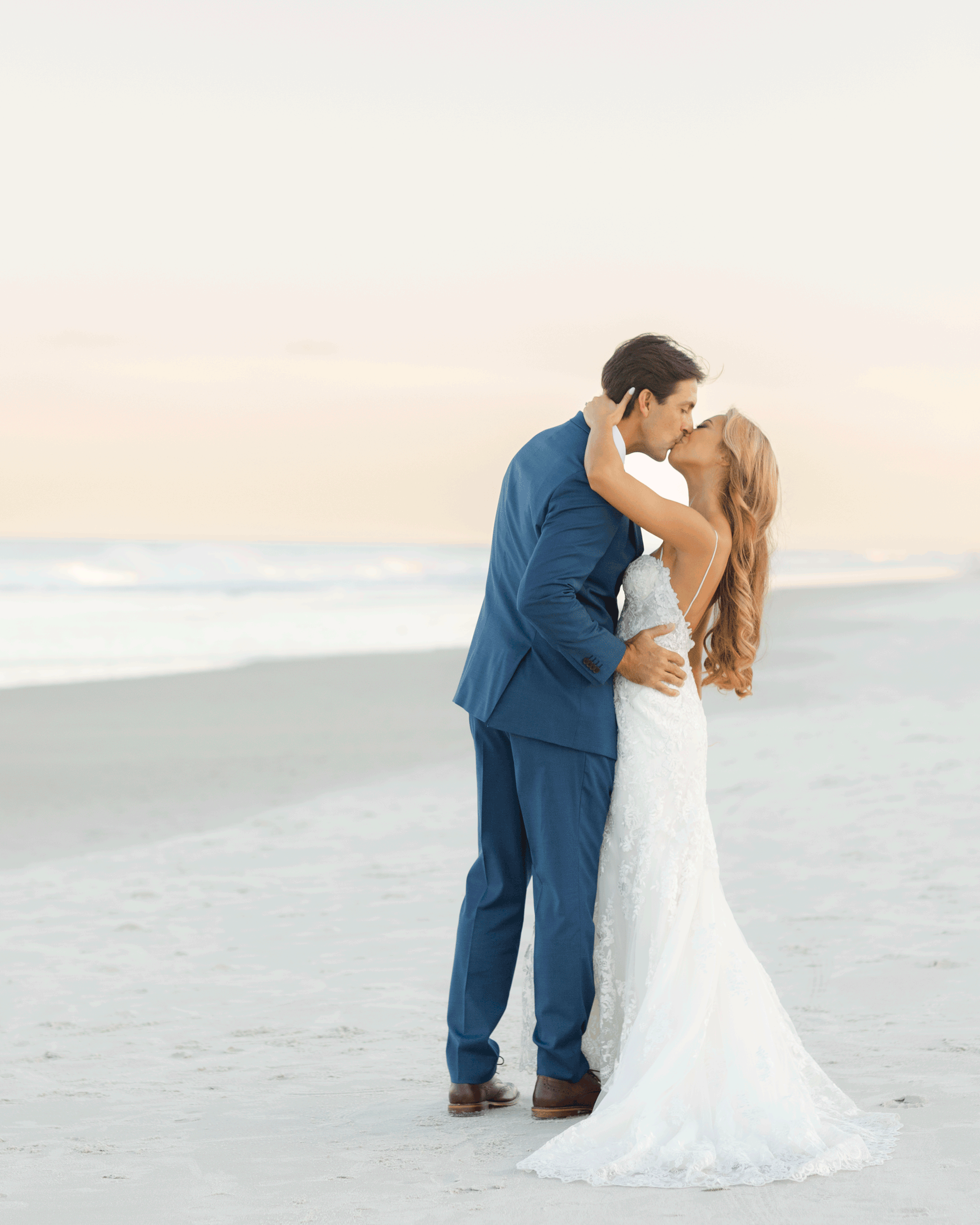 Couple kissing during wedding portraits on the beach in Ponte Vedra Florida