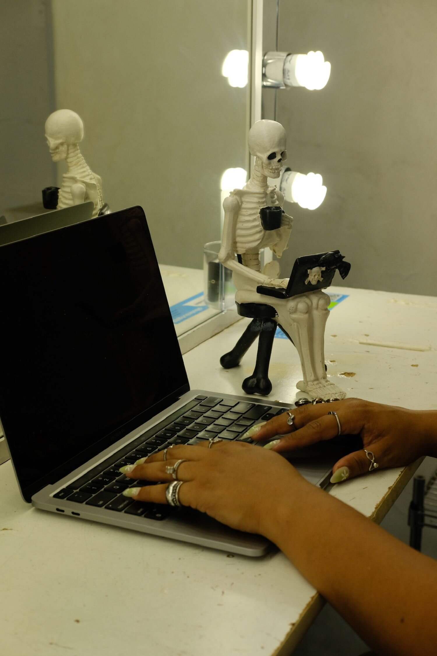 latina founder hands with long nails and rings typing on laptop